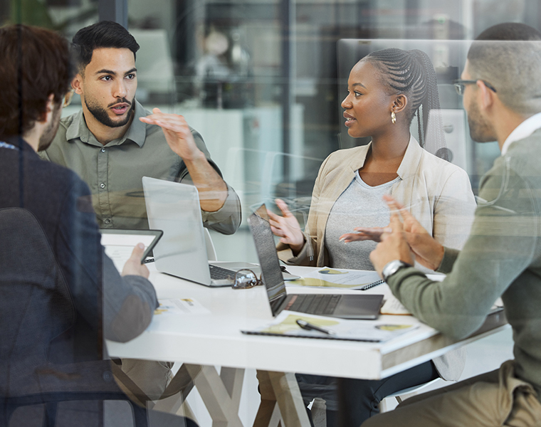 co-workers working in around a table with laptops