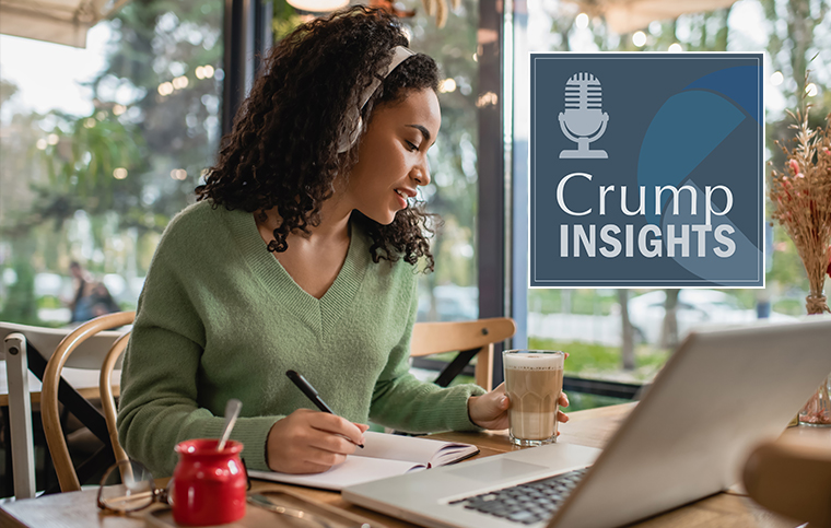 women at desk listening to podcast